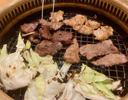 焼肉屋の無煙ロースターで焼肉を焼く 焼肉屋の無煙ロースターで焼肉を焼くの写真