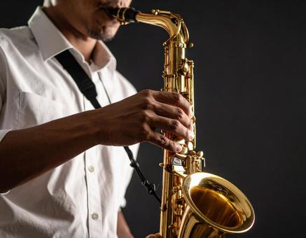 バリトンサックスを演奏する男性 バリトンサックスを演奏する男性の写真