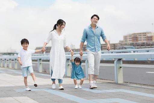 手を繋いで屋外を散歩する親子 手を繋いで屋外を散歩する親子 人物,家族,女性の写真素材
