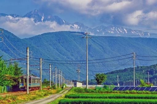 信州の夏景色、山々を背景に走るローカル線 信州の夏景色、山々を背景に走るローカル線 長野,大町,北アルプスの写真素材