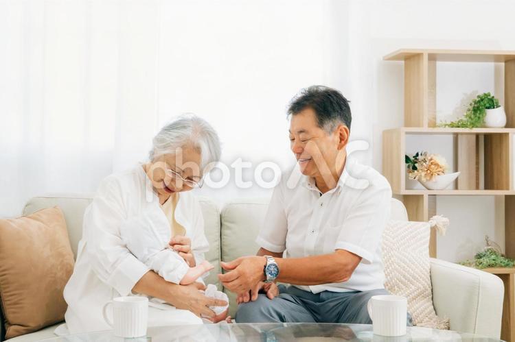 孫を抱く高齢者女性と男性 孫,初孫,孫育ての写真素材