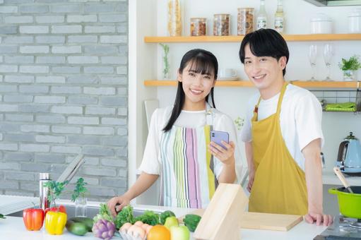 キッチンで料理を作る若い夫婦 キッチンで料理を作る若い夫婦 夫婦,料理,キッチンの写真素材