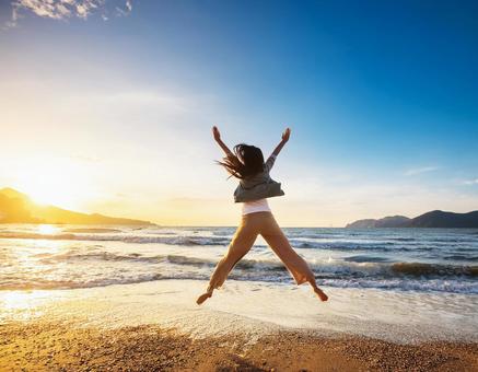 砂浜でジャンプする男性の写真