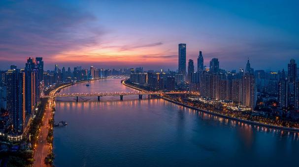 夕焼けに染まる空と川面に映る都市の写真