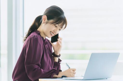 デスクワークをする笑顔の女性 女性,人物,スマホの写真素材