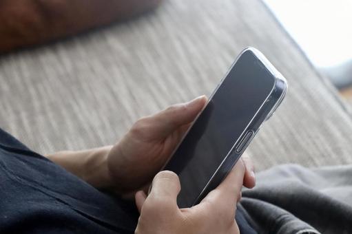 スマホを持つ男性の手 スマホを持つ男性の手の写真