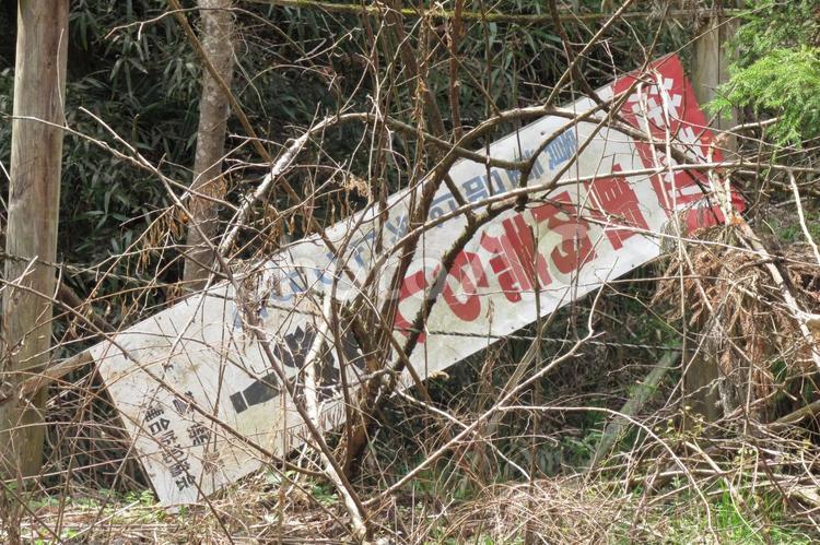 林道脇の草むらに捨てられた盗難防止の看板 看板,立て札,注意喚起の写真素材