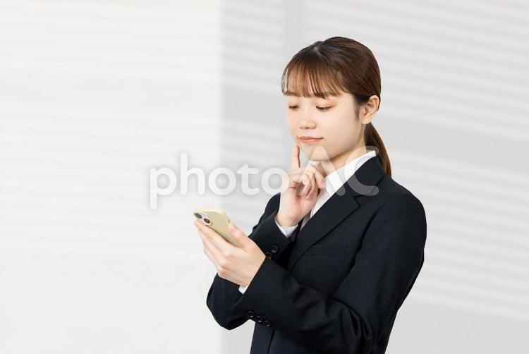 スマホを見て考えるビジネスウーマン 女性,スマホ,ビジネスの写真素材