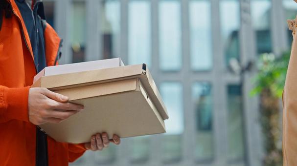 屋外でピザのデリバリーをする男性の手元 配達,デリバリー,配送の写真素材