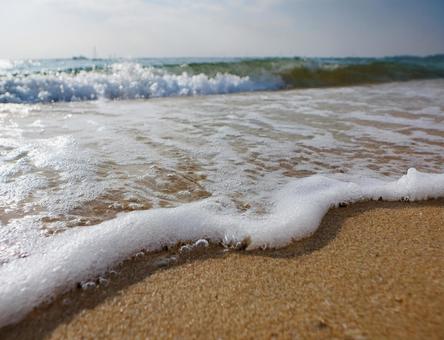砂浜と波打ち際の白い波 砂浜と波打ち際の白い波の写真
