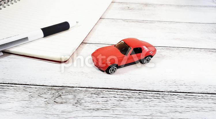 赤い車と筆記用具(白背景)(引き) 車,運転,免許更新の写真素材