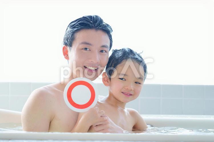 お風呂でマルの札を上げる親子 お風呂,親子,父子の写真素材