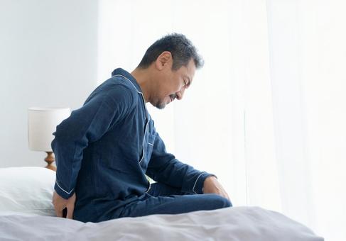 朝起きたら体調の悪いミドルの男性 朝起きたら体調の悪いミドルの男性 男性,ミドル,腰痛の写真素材