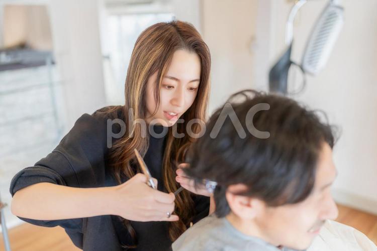 お客さんと会話をしながら髪を切る美容師 ビジネス,ビジネスウーマン,キャリアウーマンの写真素材