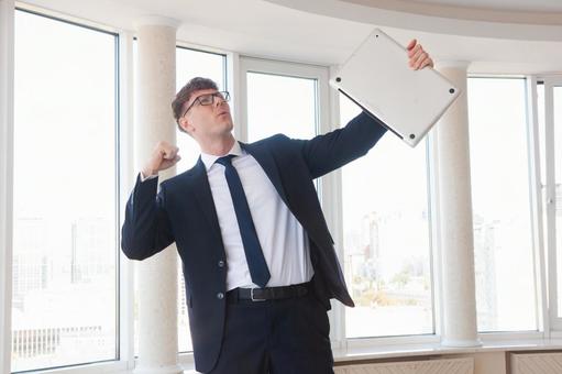 左手にパソコンを持ち喜ぶ男性 男性,外国人,ノートパソコンの写真素材