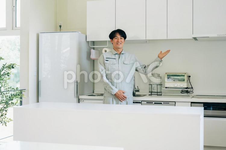 キッチンと作業着姿の男性　 工務店,作業服,設備の写真素材