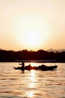夕暮れの水面を進む小舟 夕暮れの水面を進む小舟 夕暮れ,船,水面の写真素材