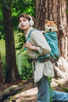 犬を背負い笑顔を見せる男性の写真