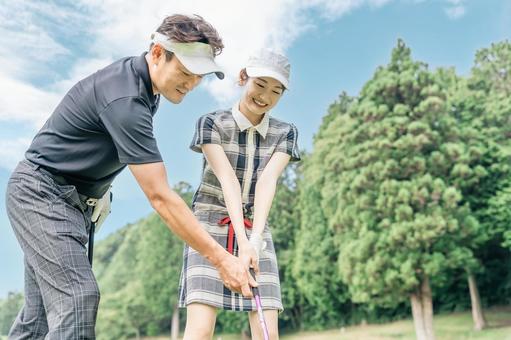 ゴルフレッスンするゴルファーの男女 ゴルフレッスンするゴルファーの男女 ラウンドレッスン,ゴルフ,ティーショットの写真素材