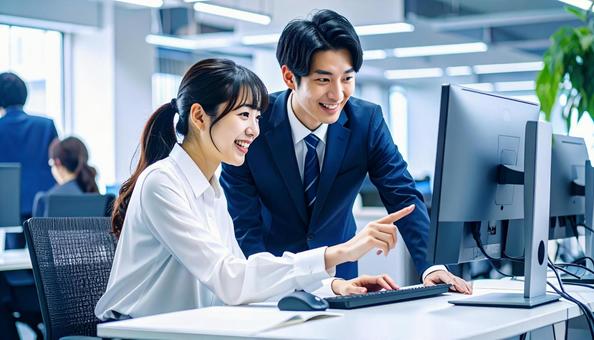 パソコンを見ながら打ち合わせをする社員 パソコンを見ながら打ち合わせをする社員の写真