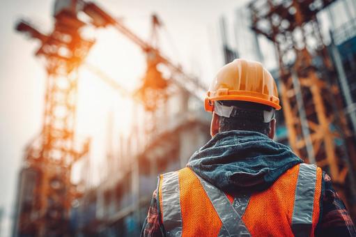 安全ヘルメットとベストを着用した建設現場の写真