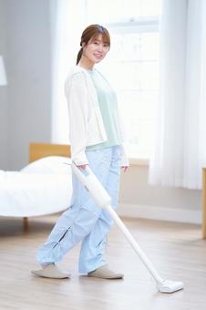 笑顔で掃除機で掃除中の女性 女性,掃除機,掃除の写真素材