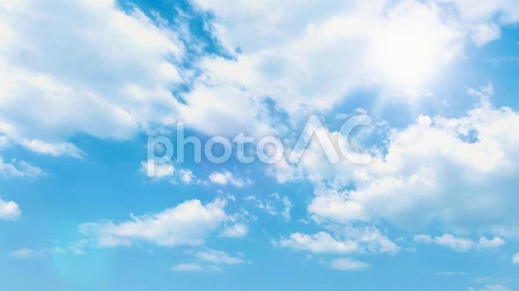 美しい青空と、白い雲と太陽の光の背景 空,太陽,光の写真素材