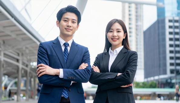 腕組する若い男女ビジネスパーソンの写真