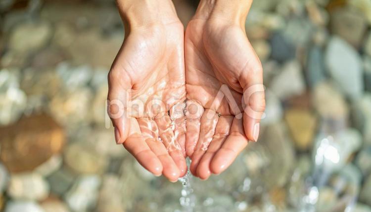 清流の綺麗な水を両手ですくう女性の手元 手,水,すくうの写真素材