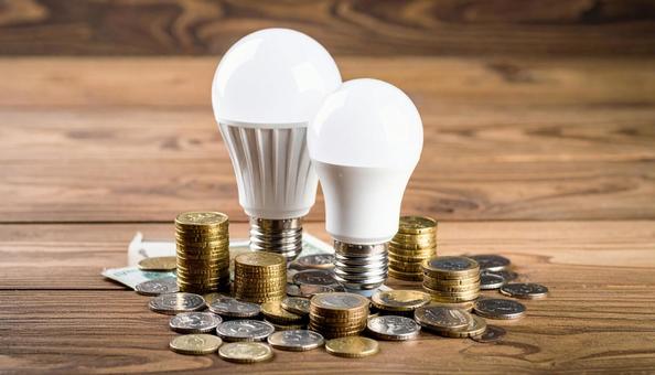デスクに置かれた小銭とLED電球 デスクに置かれた小銭とLED電球の写真