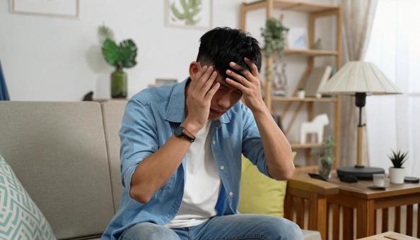 頭を抱える男性の室内ポートレート 頭を抱える男性の室内ポートレートの写真