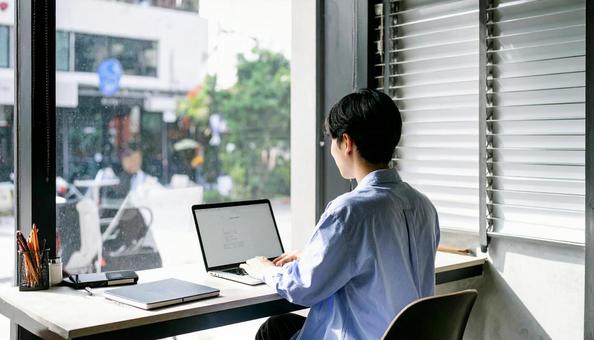 カフェで仕事をするフリーランス男性 カフェで仕事をするフリーランス男性の写真