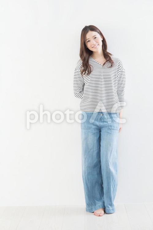 若い女性　白壁　寄りかかる　 女性,寄りかかる,白壁の写真素材