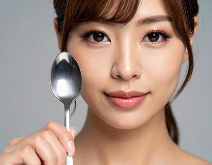 スプーンを手に持つ女性 スプーンを手に持つ女性の写真
