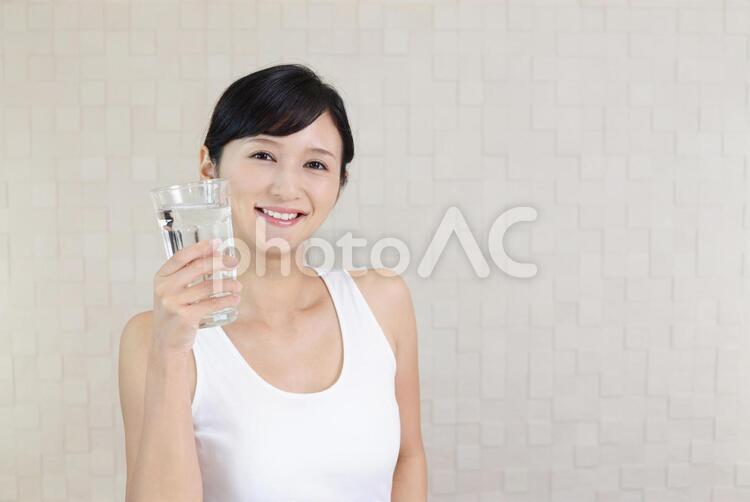 お水の入ったグラスを持つ笑顔の女性 女性,水,お水の写真素材
