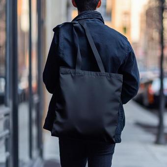 黒のファッションに身を包んだ若い男性 黒のファッションに身を包んだ若い男性の写真