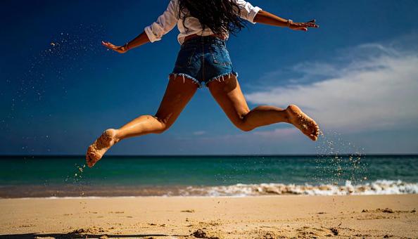 砂浜をジャンプする女性の足 砂浜をジャンプする女性の足の写真