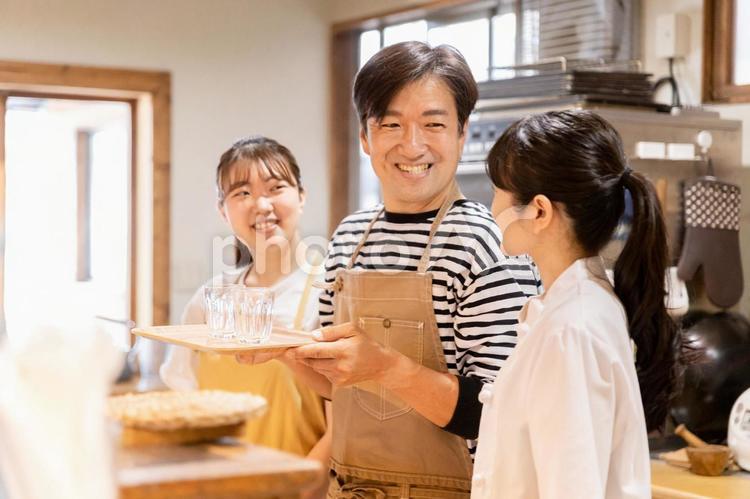 お水を持つ飲食店スタッフの男女(3人) カフェ,レストラン,飲食店の写真素材
