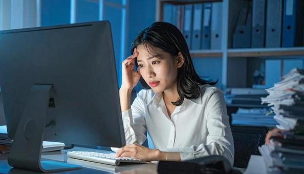 深夜残業する女性社員 深夜残業する女性社員の写真