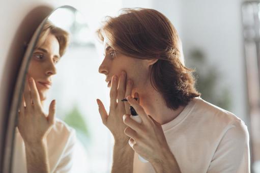 鏡を見ながらスキンケアする男性 男性,外国人,欧米人の写真素材