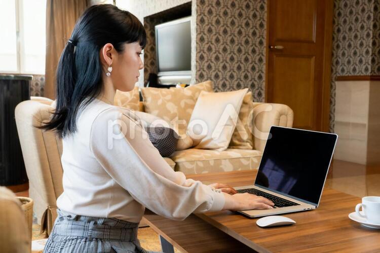 部屋でパソコンを操作する女性　テレワーク　在宅勤務 女性,テレワーク,リモートワークの写真素材