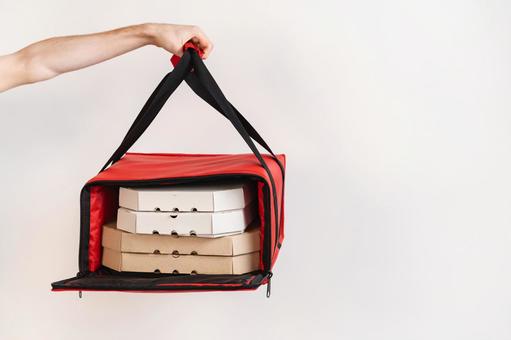 開けた保温ピザバッグを差し出す手 配達,フードデリバリー,テイクアウトの写真素材