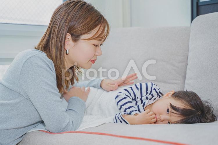 ソファーで子供を寝かしつけるママ 女性,昼寝,ぬいぐるみの写真素材