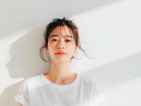 白いTシャツを着た自然光の女性 白いTシャツを着た自然光の女性の写真
