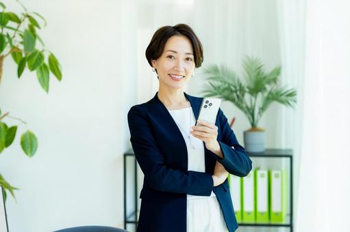 スマホを持つビジネスウーマン スマホを持つビジネスウーマン スマホ,ビジネスウーマン,キャリアウーマンの写真素材
