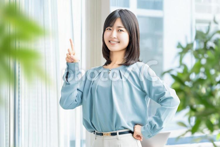 人差し指を立てて案内する笑顔の女性 女性,ビジネス,笑顔の写真素材