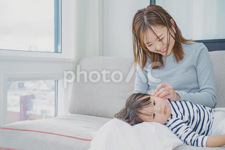 笑顔でやさしく耳かきをするお母さん 女性,耳かき,ひざまくらの写真素材