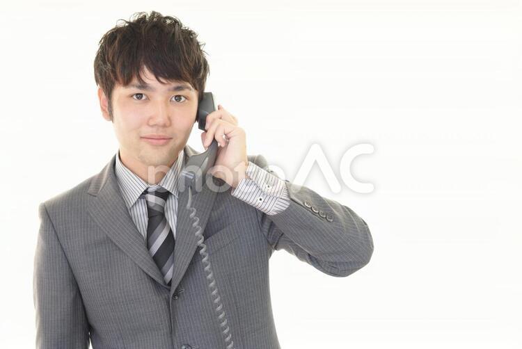 受話器を持つ笑顔のビジネスマン 男性,ビジネスマン,男の写真素材