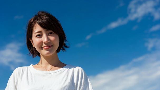 輝く笑顔と青空が印象的な夏のポートレート 輝く笑顔と青空が印象的な夏のポートレートの写真
