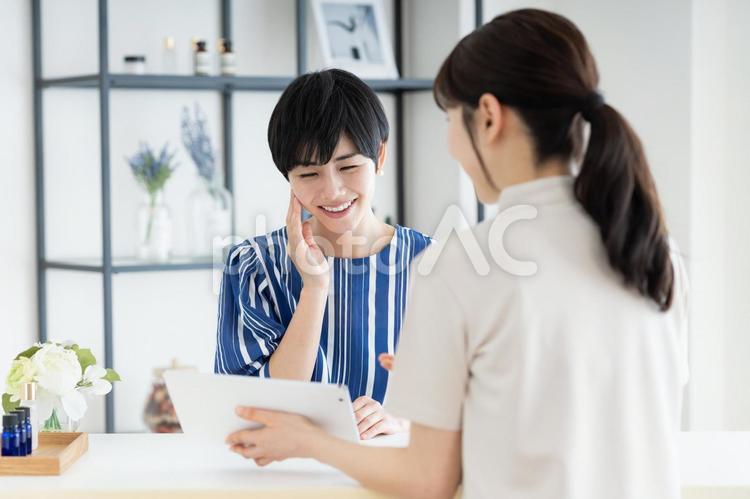 サロンの受付をする若い女性 カウンセリング,エステサロン,受付の写真素材